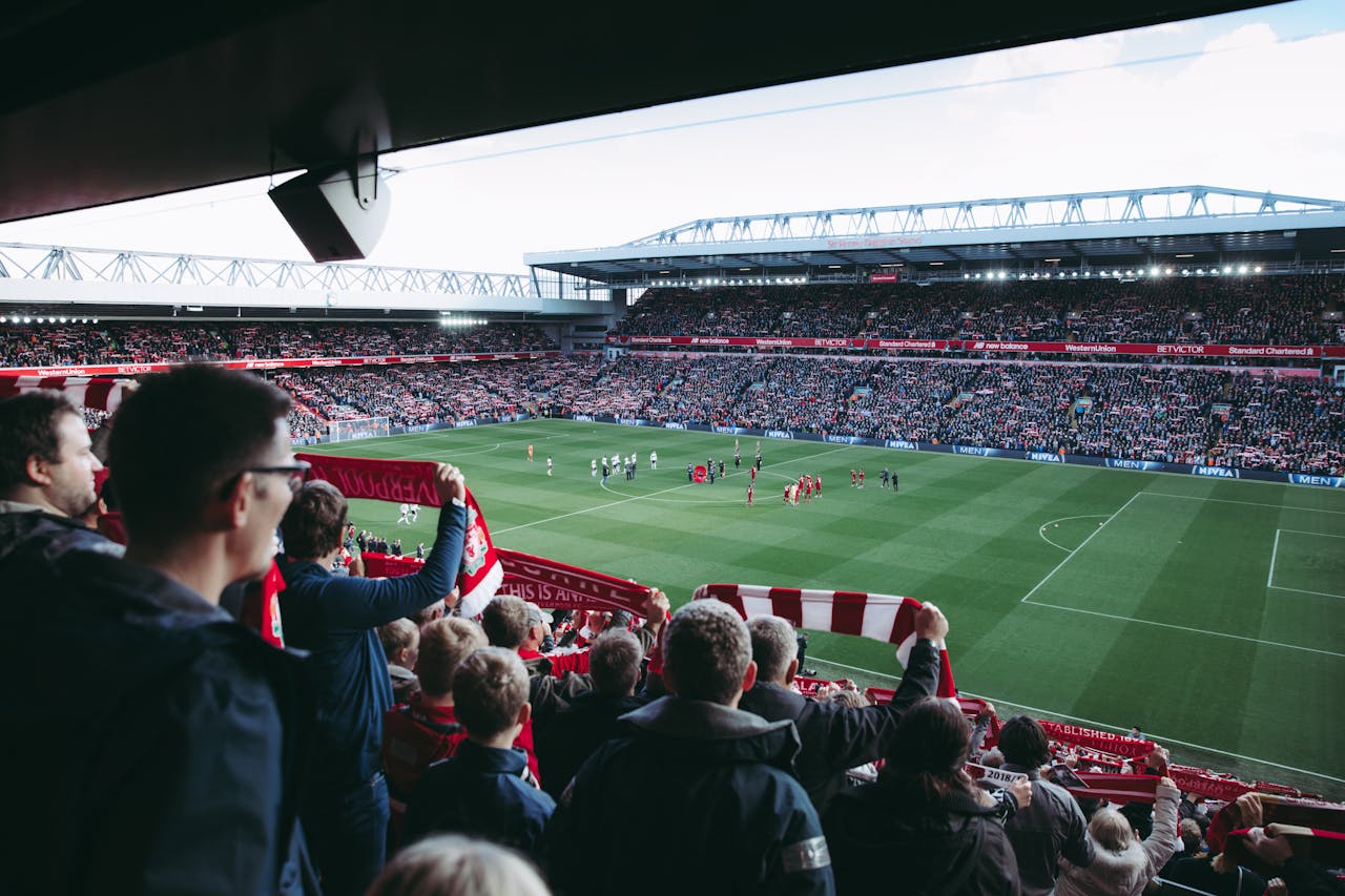 service-06 Fans cheer as players take the field at a vibrant football stadium, creating an electric atmosphere.